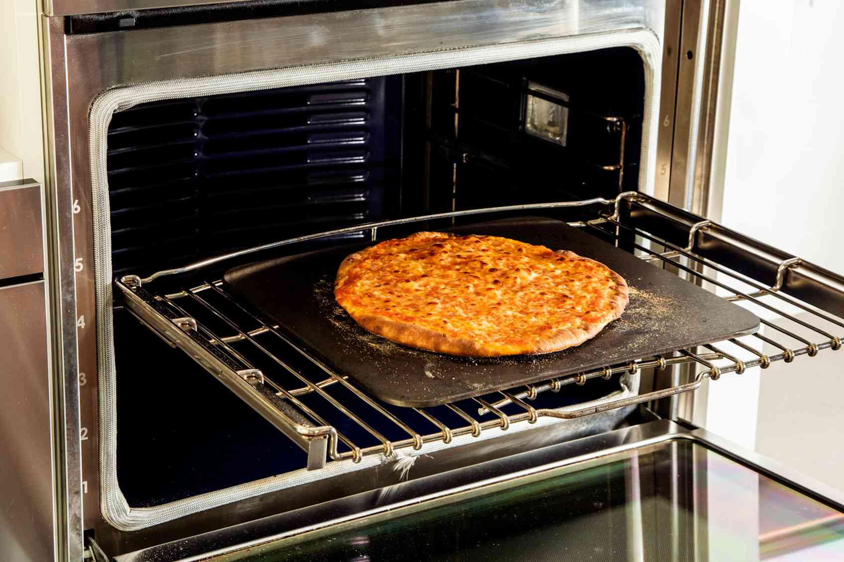 Fully baked pizza on a baking steel in the oven. 